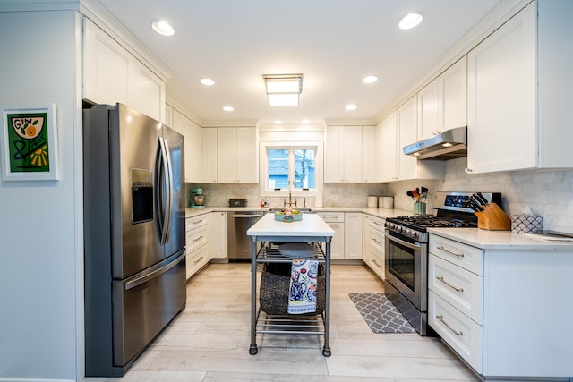 kitchen featuring stainless steel appliances, decorative backsplash, and white cabinetry