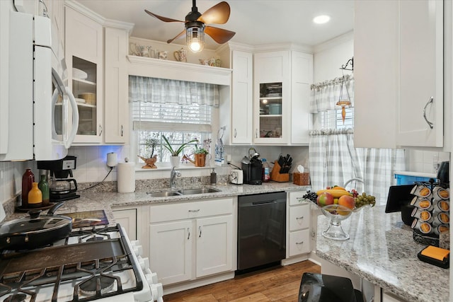 kitchen with black dishwasher, light hardwood / wood-style flooring, white cabinets, and sink