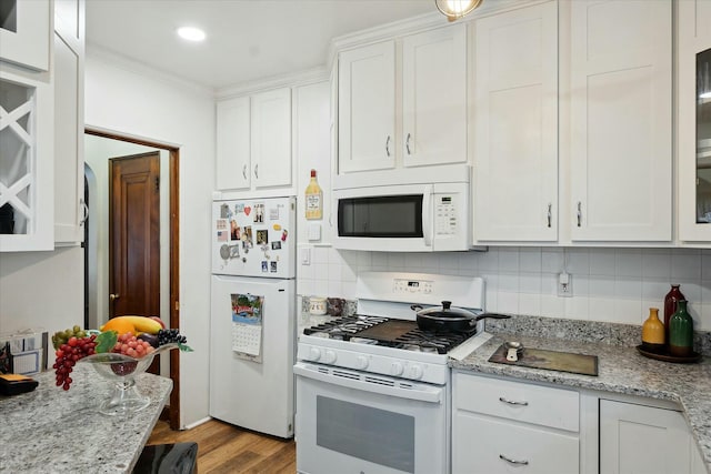 kitchen featuring white cabinets, backsplash, light stone countertops, and white appliances