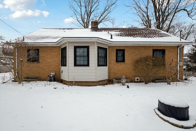 view of snow covered rear of property