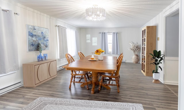 dining area with hardwood / wood-style flooring, a baseboard radiator, and a notable chandelier