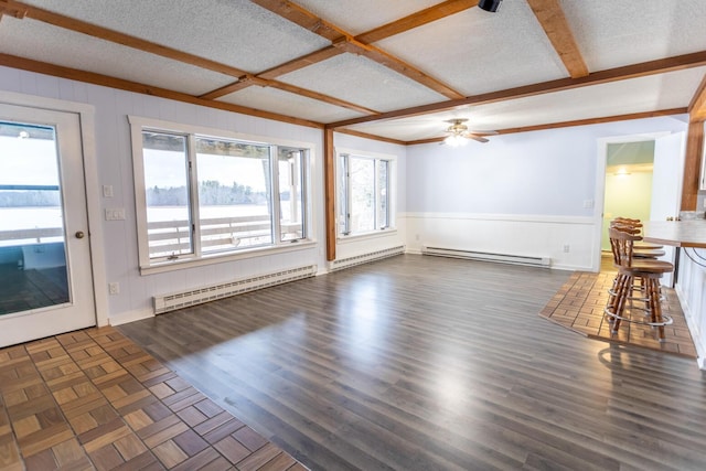 unfurnished living room featuring dark wood-type flooring, baseboard heating, coffered ceiling, and ceiling fan