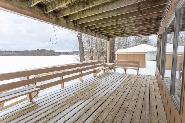 snow covered deck with a storage shed