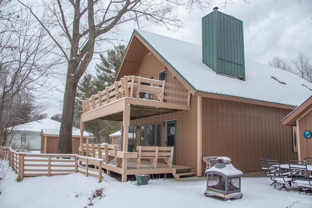 snow covered property featuring an outdoor fire pit and a deck