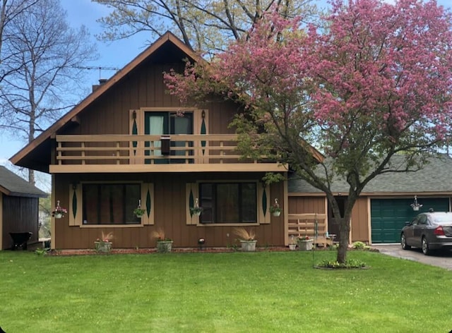 view of front facade with a balcony, a front lawn, and a garage