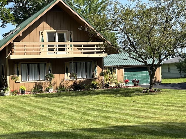 view of front facade with a garage, a front lawn, and a balcony