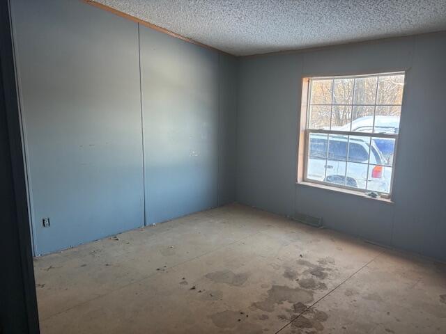 unfurnished room featuring a textured ceiling