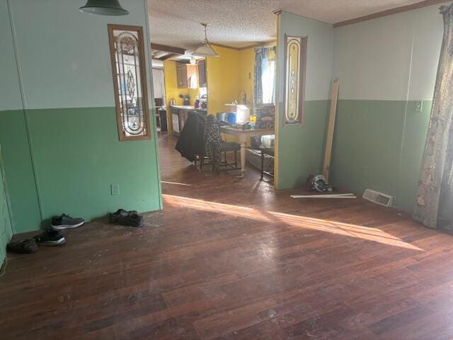 unfurnished room with a textured ceiling and dark hardwood / wood-style floors