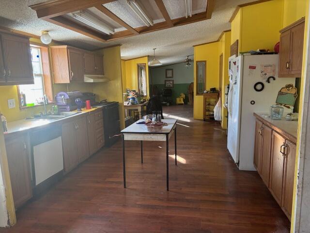 kitchen with a textured ceiling, dark hardwood / wood-style flooring, white refrigerator, ceiling fan, and sink