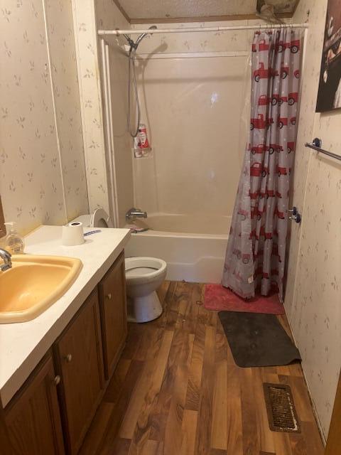 full bathroom featuring toilet, wood-type flooring, vanity, and shower / bath combination with curtain