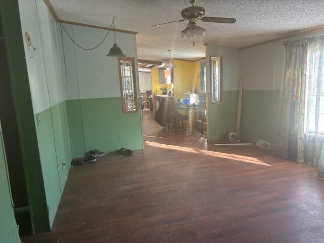 unfurnished room with ceiling fan, a textured ceiling, and dark hardwood / wood-style floors