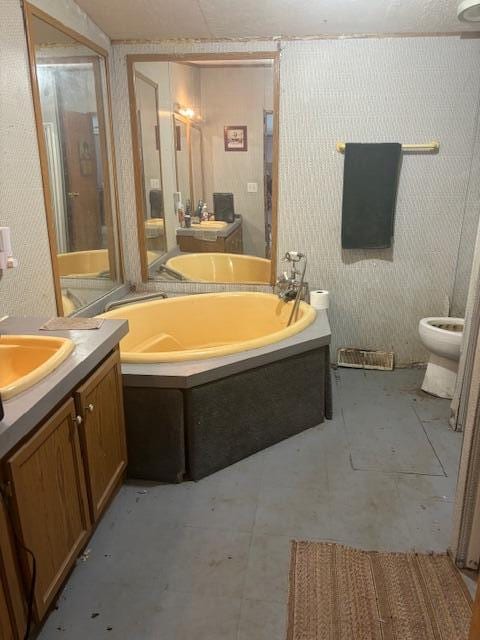 bathroom featuring a bath, vanity, and toilet