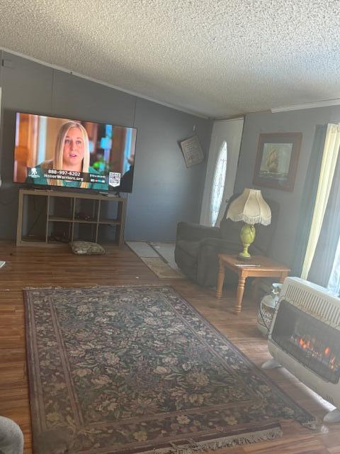 living room featuring a textured ceiling, hardwood / wood-style floors, and heating unit