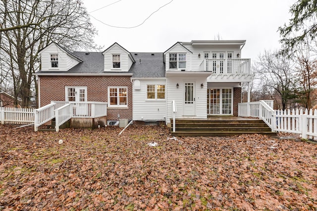 back of property featuring a balcony and french doors