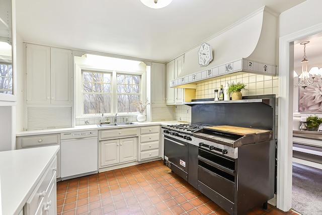 kitchen featuring sink, tasteful backsplash, plenty of natural light, white dishwasher, and white cabinets