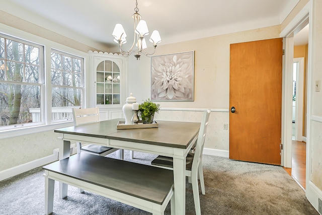 dining area with carpet flooring and a notable chandelier