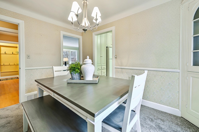 dining room with an inviting chandelier and carpet