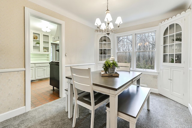 carpeted dining room featuring a chandelier