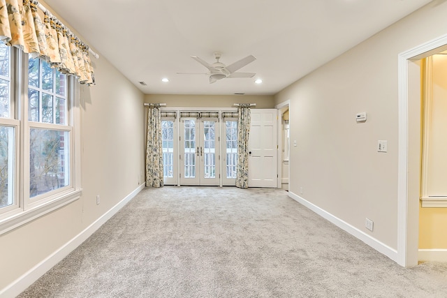 carpeted spare room with french doors and ceiling fan