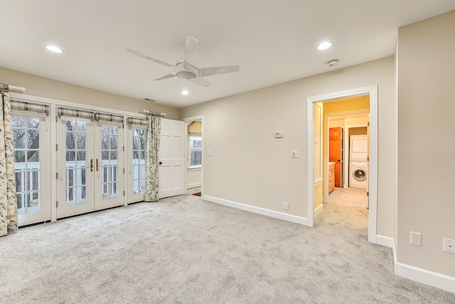 unfurnished room featuring french doors, light colored carpet, washer / clothes dryer, and ceiling fan