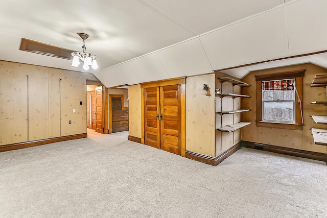 unfurnished room with lofted ceiling, carpet flooring, and a chandelier