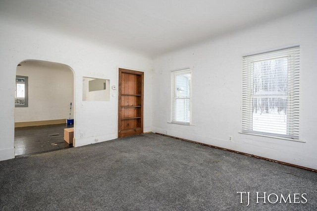 unfurnished room with dark carpet