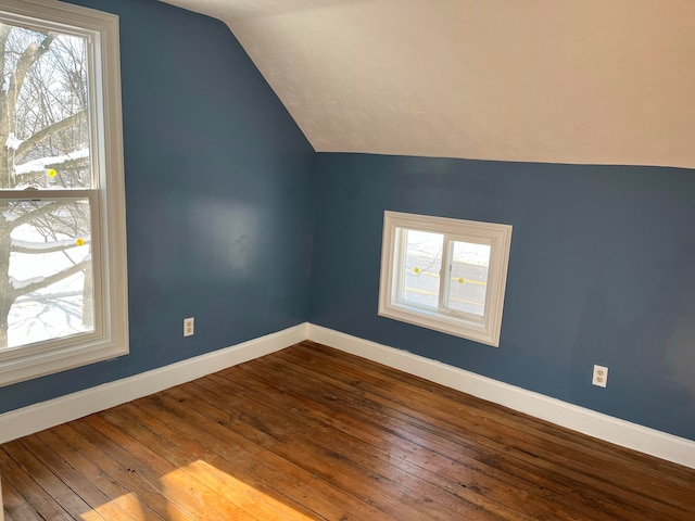 bonus room with hardwood / wood-style floors and vaulted ceiling