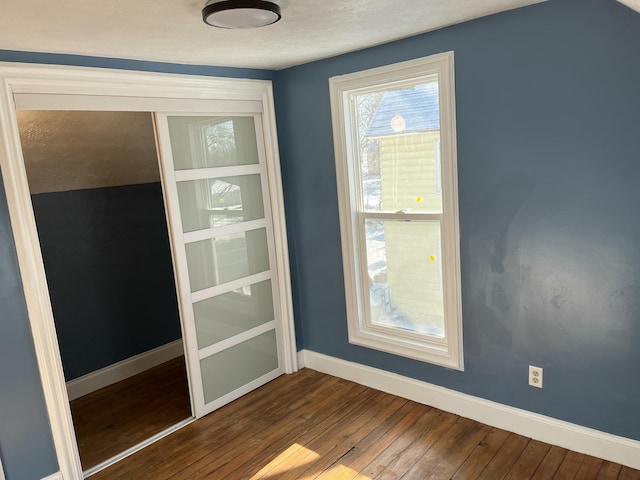 unfurnished room with a textured ceiling and hardwood / wood-style floors