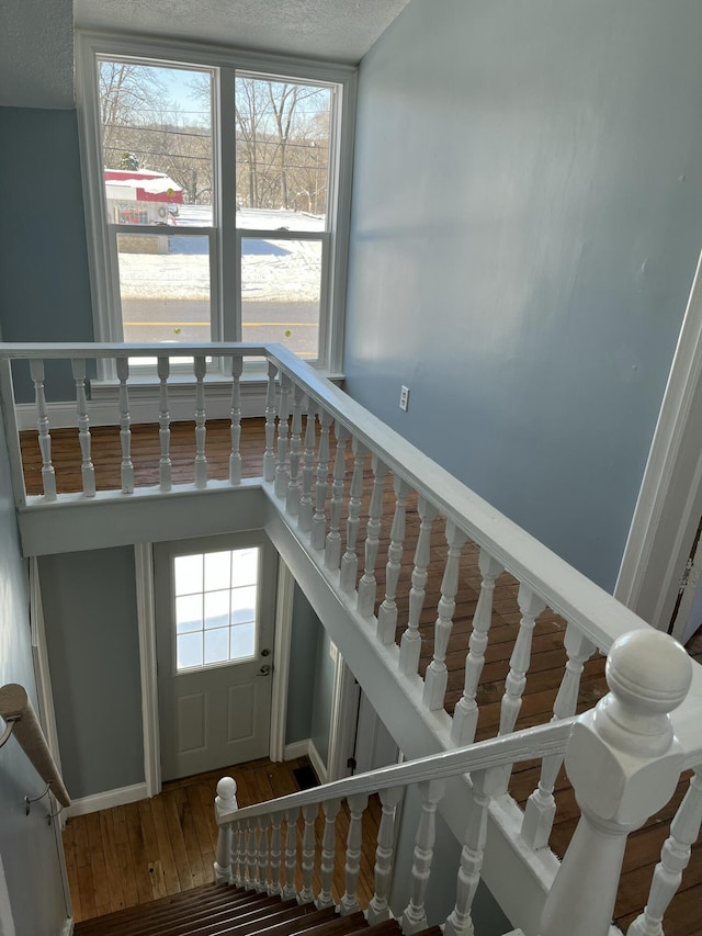 staircase featuring a textured ceiling and hardwood / wood-style floors