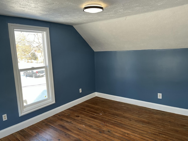 bonus room featuring lofted ceiling, a textured ceiling, and dark hardwood / wood-style flooring