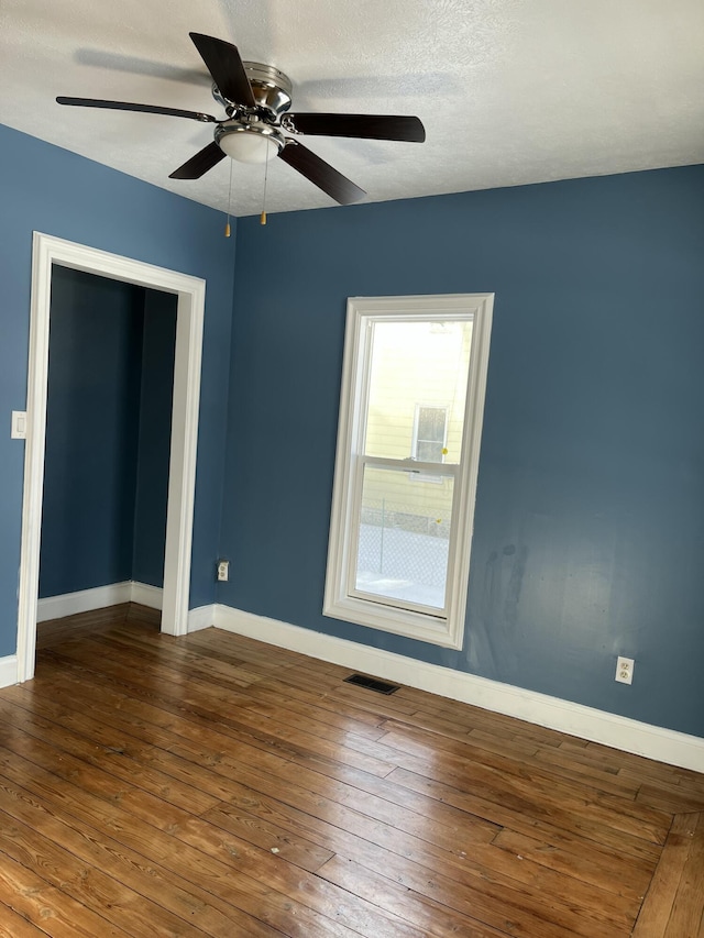 spare room featuring ceiling fan and dark wood-type flooring