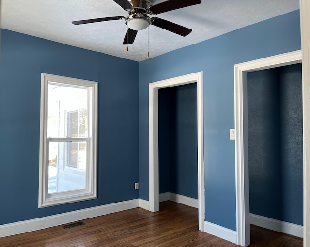 unfurnished bedroom featuring a textured ceiling, ceiling fan, and dark hardwood / wood-style flooring