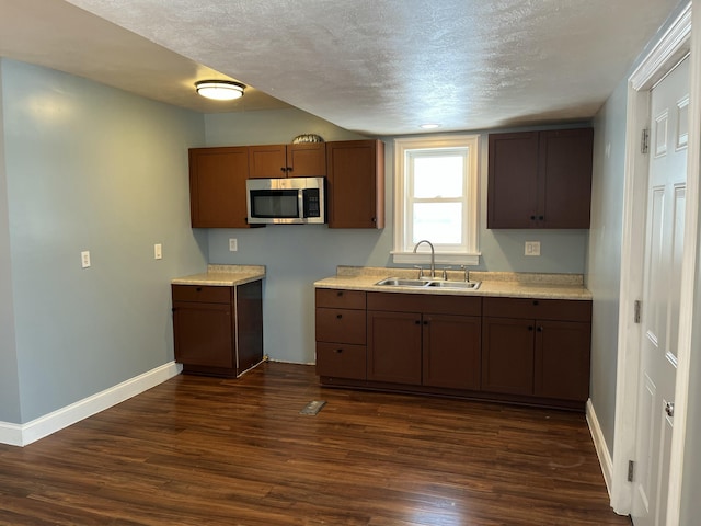 kitchen with sink, dark hardwood / wood-style flooring, and a textured ceiling