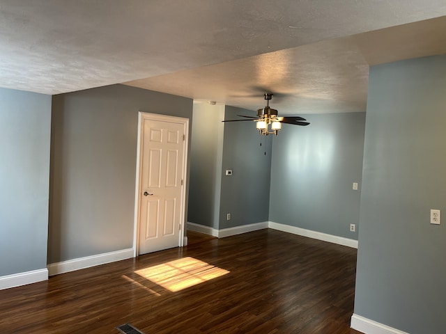 unfurnished room with ceiling fan, dark wood-type flooring, and a textured ceiling