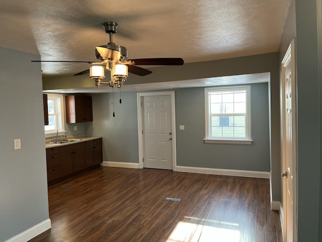 kitchen with dark wood-type flooring, a textured ceiling, ceiling fan, and sink