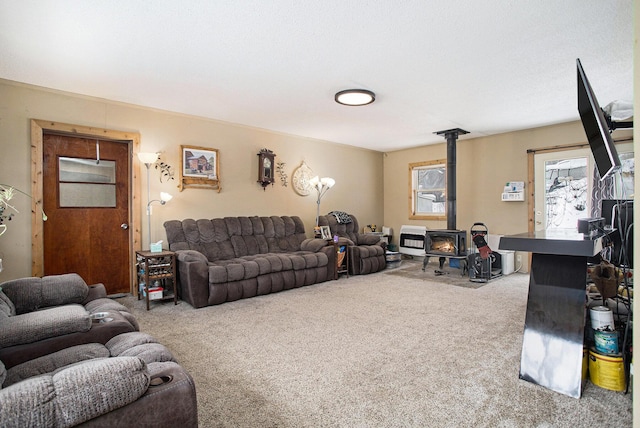 carpeted living room with heating unit and a wood stove