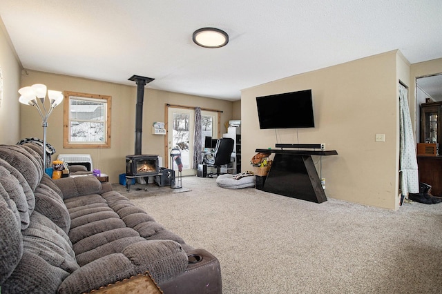 living room with carpet floors, a wealth of natural light, and a wood stove