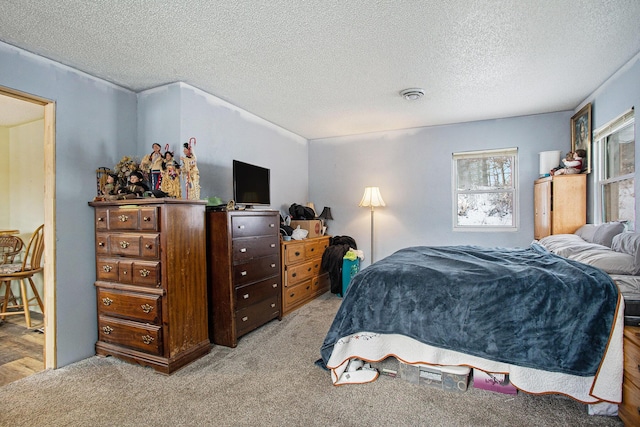 bedroom featuring light carpet and a textured ceiling