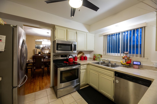 kitchen featuring cream cabinets, light tile patterned flooring, appliances with stainless steel finishes, ceiling fan, and sink