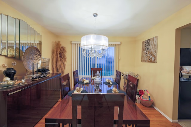 dining area with hardwood / wood-style flooring and a notable chandelier