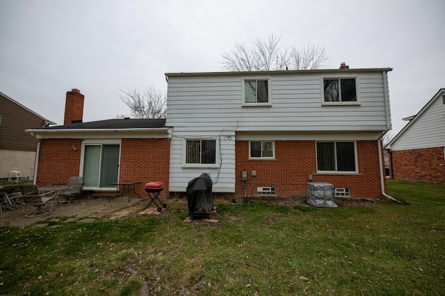 back of house featuring a patio and a lawn