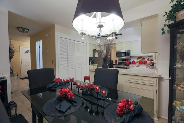 tiled dining space with a chandelier