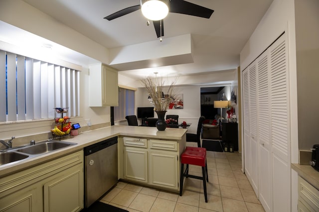 kitchen featuring dishwasher, a breakfast bar area, kitchen peninsula, sink, and light tile patterned flooring