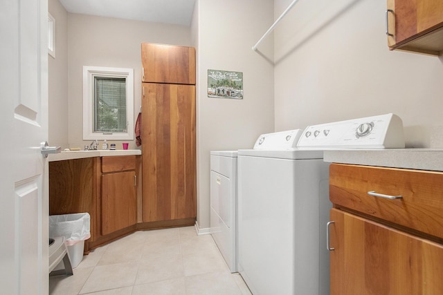 laundry room with cabinets, washing machine and dryer, and light tile patterned flooring