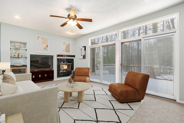 carpeted living room with ceiling fan and plenty of natural light