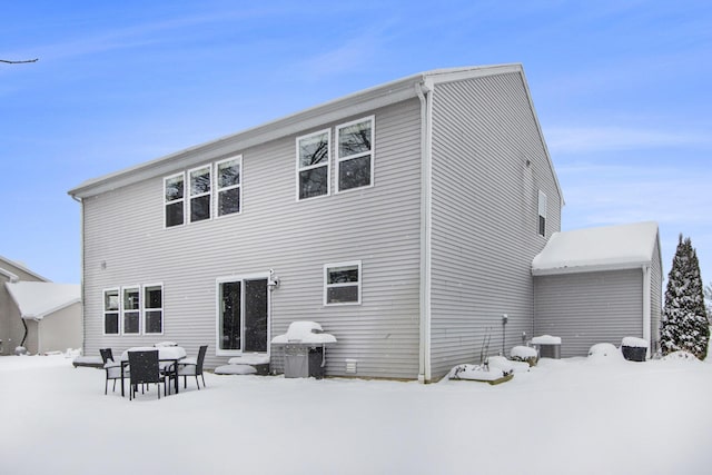 view of snow covered back of property