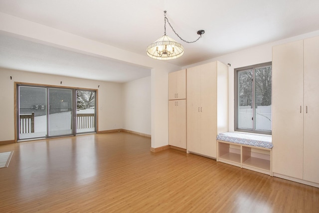 unfurnished room with a chandelier and hardwood / wood-style flooring