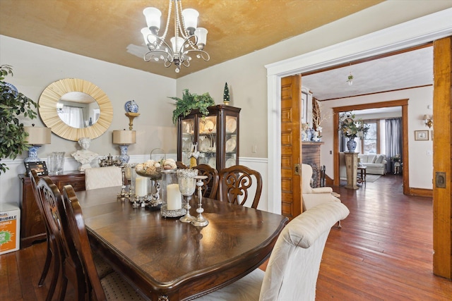 dining room with dark hardwood / wood-style floors and a notable chandelier