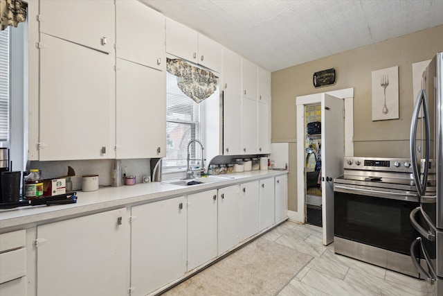 kitchen with sink, white cabinetry, stainless steel appliances, and a textured ceiling