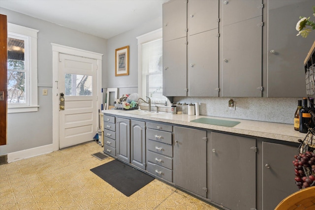 kitchen with decorative backsplash, sink, and gray cabinetry